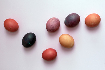 multicolored easter painted eggs in red colors on a pink background
