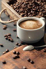Black fried coffee beans on dark textured background
