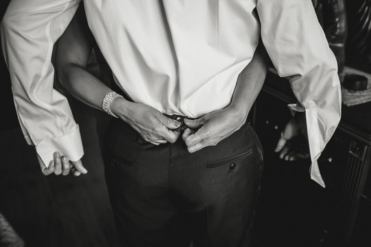 Hands buttoning trousers for man