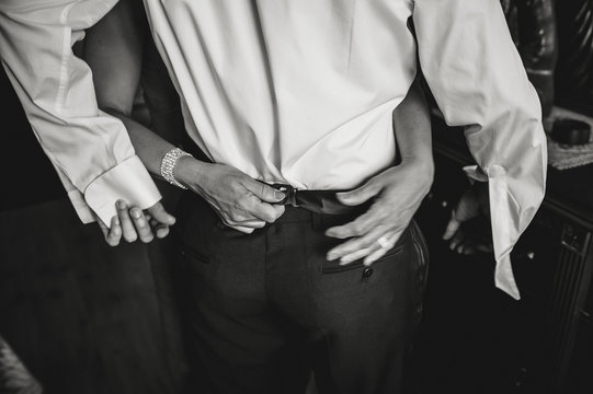 Hands buttoning trousers for man