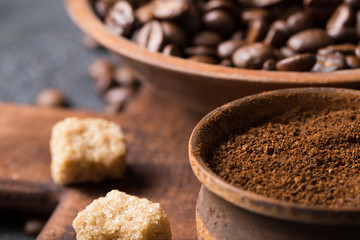 Black fried coffee beans on dark textured background