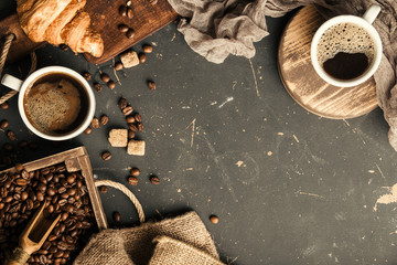Black fried coffee beans in cafe with cookie and cake on dark textured background