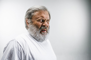 Obraz premium Senior man with disgusted expression repulsing something on white