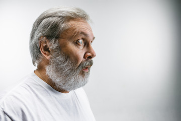 Obraz premium The senior attractive man looking suprised isolated on white