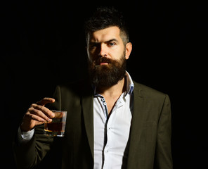 Connoisseur with elegant look drinks cognac or brandy