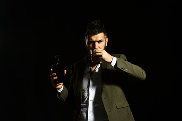 Man holding glass of whiskey or bourbon and bottle