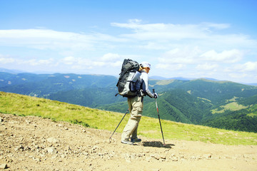 Summer hike in the mountains with a backpack and tent.