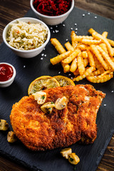 Fried pork chop, French fries and vegetable salad