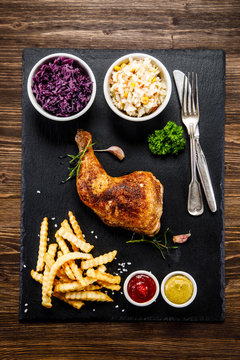 Grilled chicken legs with French fries and vegetables