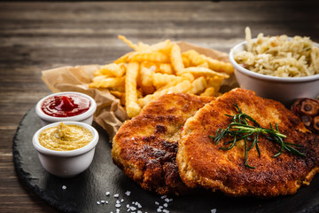 Fried pork chop, French fries and vegetable salad