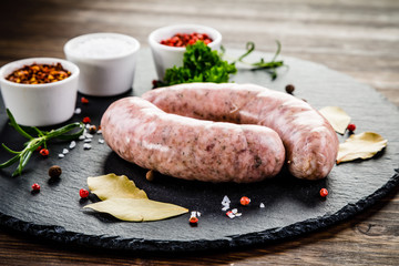 Raw sausages on wooden table