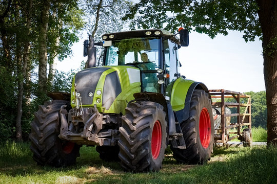 Rinderaustrieb im Frühjahr, Traktor mit Fangwagen fährt in eine Weide