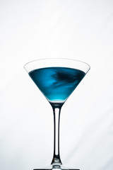 blue cocktail in a martini on a white background