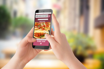 Female person holding phone and ordering food with app in restaurant