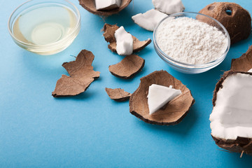 Plate with coconut flour and water on blue background