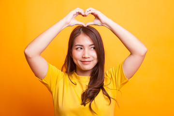 Young Asian woman gesturing  heart hand sign.