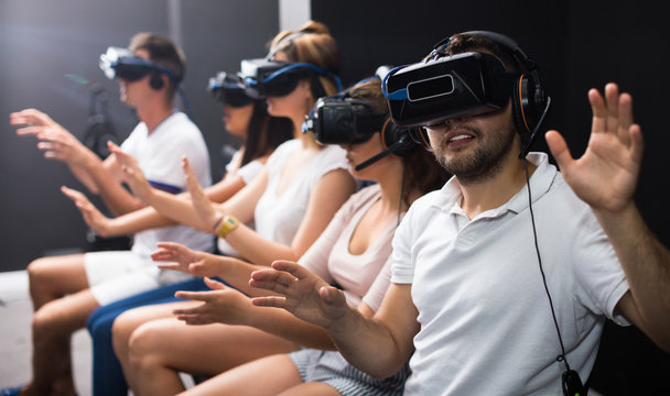 Guy is enjoying exciting movie with friends in VR glasses