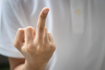 Obraz premium rude mand hand showing middle finger; hand flipping rude middle finger rude, aggressive, hostile, unfriendly hand sign; man hand close up shot