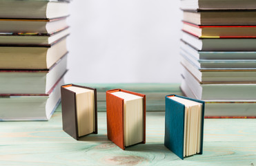 Pile of various books on bright wooden background. With copy space for your text