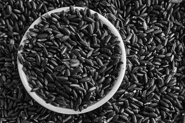 Monochrome Texture of Coarse black rice in white plate The concept of proper nutrition and healthy...