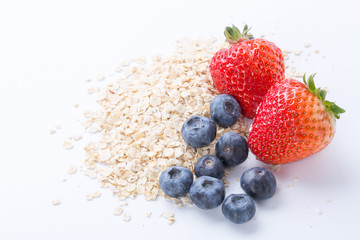 Closeup of oatmeal with berries on white background.