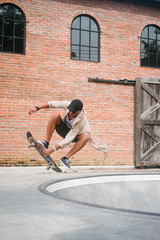 handsome skater jumping out of pool in skatepark