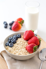 Oatmeal with fresh fruit and milk. Strawberry and blueberry.