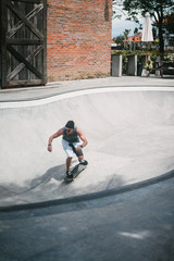 handsome skater skating in pool in skatepark in Bali, Indonesia