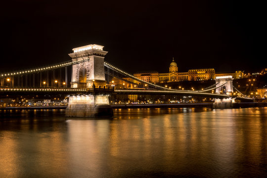 The Chain Bridge with the Royal Palace in the background in Budapest at night - Powered by Adobe