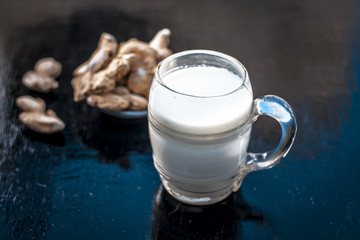 Dried ginger or Zingiber officinale with milk on wooden surface helps in Toner, Chest Pain, Anti-Inflammatory, Common Cold.