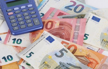 different euros are lying in the studio with a blue calculator