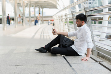 Handsome hipster modern business man using smart phone in the city. concept of communication online.