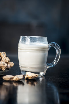 Dried ginger or Zingiber officinale with milk on wooden surface helps in Toner, Chest Pain, Anti-Inflammatory, Common Cold.