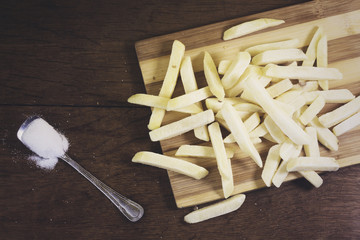 Freeze potato stick and salt spoon on wooden cutting board