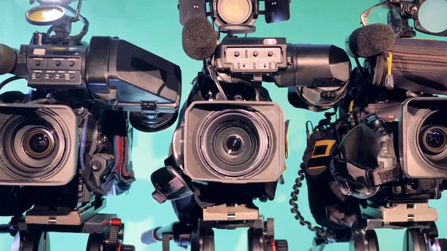 Zoomed-out image of three professional camcorders
