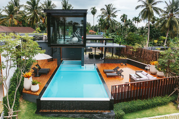 Private tropical swimming pool and gym near luxury villa. Sunny summer travel vacation, palm trees...