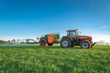 Unkrautbekämpfung im Frühjahr -Traktor mit Feldspritze im Getreide