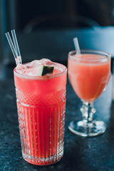 Vintage glasses with watermelon and grapefruit juice on the grey background