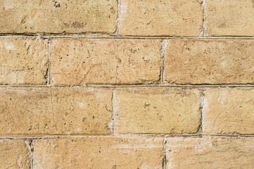 Close-up Textured background of a stone brick of yellow antediluvian masonry. Partially destroyed wall. Brick grunge background in vintage style