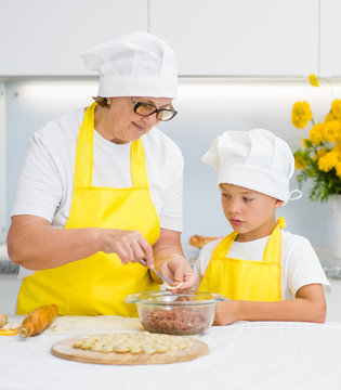 grandmother teaches her grandson to make a dumplings