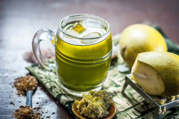 Close up of Indian and Asian famous mango juice AAM PANNA in a transparent glass with ice cubes and cumin powder ,sugar, and black salt in dark Gothic colors.