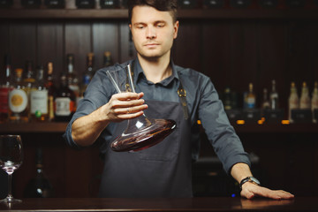 Bartender decanting wine without disturbing the sediment
