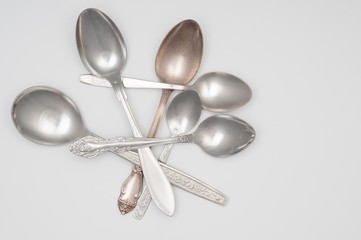 Pile of old spoons close up on gray background