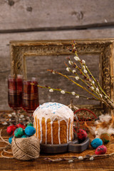 A table served for Easter. Fresh Russian cake and dyed quail eggs on a wooden background. With an ancient frame in the background. Easter greeting card.