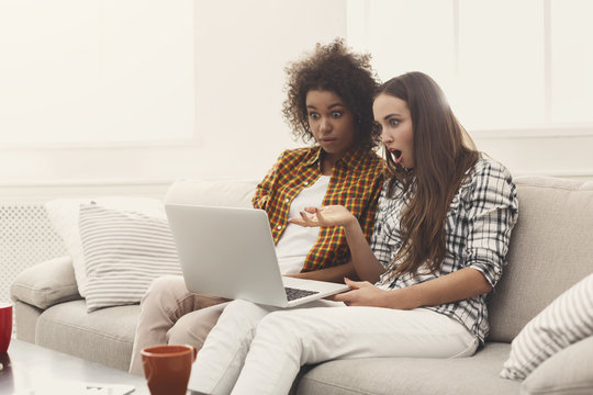 Two beautiful women using laptop at home