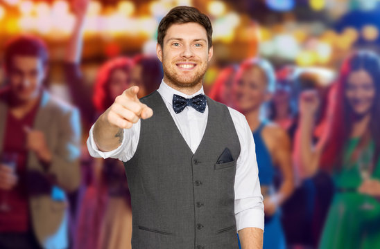 party, people and gesture concept - happy man in festive suit pointing finger at you over night club background
