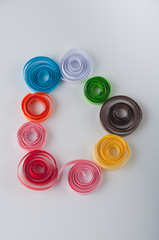 Different colored paper spirals laying in shape of letter D