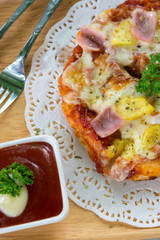 Tasty crispy oven-baked tortilla pepperoni pizza with spicy Italian sausage, melted cheese and tomato with a single slice being served in a restaurant, top view