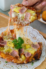 Tasty crispy oven-baked tortilla pepperoni pizza with spicy Italian sausage, melted cheese and tomato with a single slice being served in a restaurant, close up view