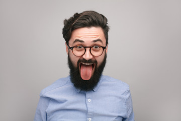 Bearded man showing tongue - obrazy, fototapety, plakaty